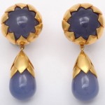 A pair of gold and blue earrings with a drop.