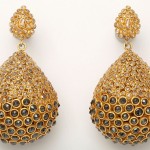 A pair of gold earrings with large, round stones.