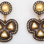 A pair of earrings with gold and diamond accents.