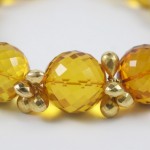 A close up of a bracelet with yellow beads