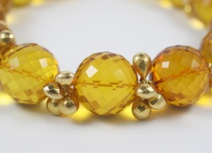 A close up of a bracelet with yellow beads