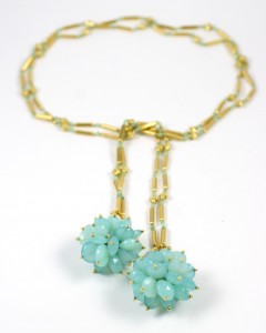 A necklace with two turquoise beads hanging from it.