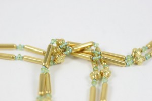 A close up of the gold beads on a necklace