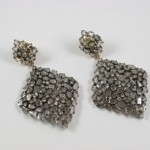 A pair of earrings with silver beads on them.