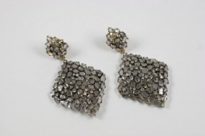 A pair of earrings with silver beads on them.
