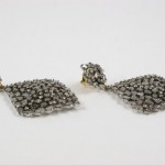 A pair of earrings with silver beads on them.