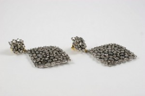 A pair of earrings with silver beads on them.
