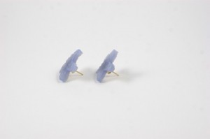 A pair of blue earrings sitting on top of a white surface.