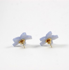 A pair of earrings with blue flowers on them.
