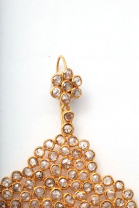 A pair of gold earrings with clear stones.