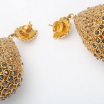 A pair of gold earrings with black diamonds.