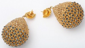 A pair of gold earrings with black diamonds.