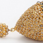 A close up of the bottom part of a gold earring