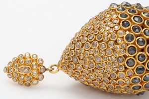 A close up of the bottom part of a gold earring