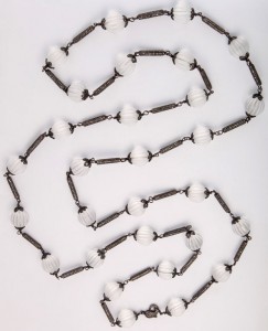 A long necklace with white beads and black metal