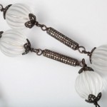 A close up of a necklace with white beads