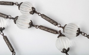 A close up of a necklace with white beads