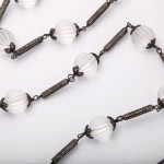 A close up of a chain with glass beads