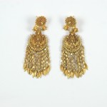 A pair of gold earrings with dangling chains.