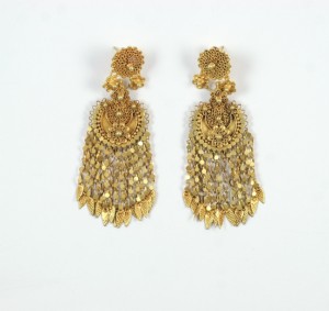 A pair of gold earrings with dangling chains.