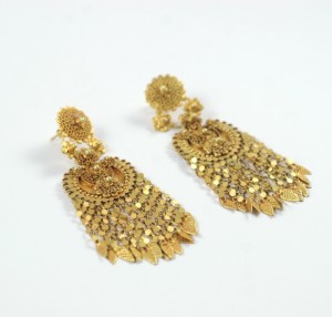 A pair of gold earrings with dangling chains.