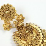 A close up of a gold earring