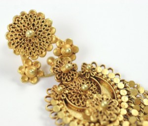 A close up of a gold earring