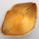 A gold lip dish with the mouth open.