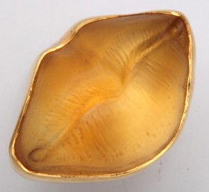 A gold lip dish with the mouth open.