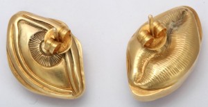 A pair of gold earrings with a design on them.