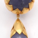 A pair of gold and blue earrings.