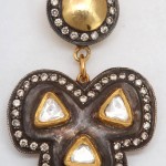 A close up of a earring with some gold and diamond