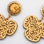 A pair of gold earrings with floral design.