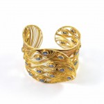 A gold bracelet with blue stones on it.