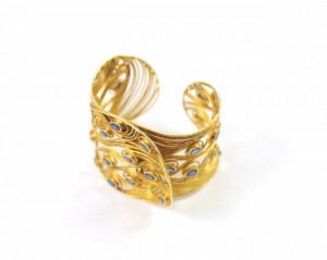A gold bracelet with some blue stones on it