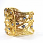 A gold bracelet with blue stones on it.