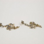 A pair of earrings with gold and silver flowers.