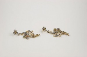 A pair of earrings with gold and silver flowers.