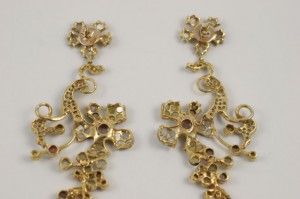 A pair of gold earrings with a floral design.