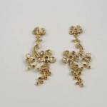 A pair of gold earrings with red stones.