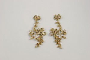 A pair of gold earrings with red stones.