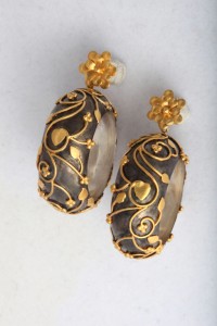 A pair of earrings with gold and black design.