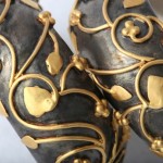 A close up of two black and gold decorated eggs.