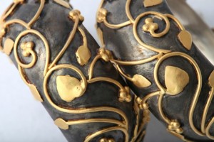 A close up of two black and gold decorated eggs.