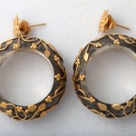 A pair of earrings with gold leaf design.