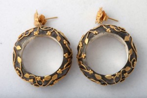 A pair of earrings with gold leaf design.