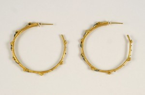 A pair of gold hoop earrings with blue stones.
