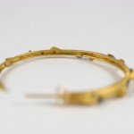 A close up of the side of a gold bracelet