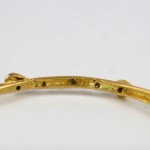 A close up of the bottom of a gold bracelet