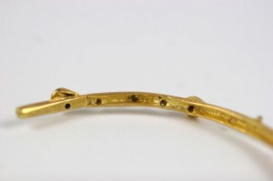 A close up of the bottom of a gold bracelet